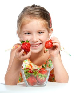 little cute girl holding a strawberry