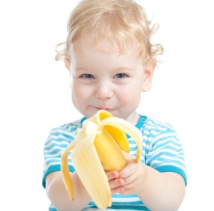 happy pretty child eating banana. healthy food eating concept.