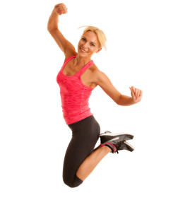 fit woman jumps over white background as a gesture of success.
